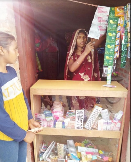 Rishu Devi selling wares to a girl at her cosmetic store