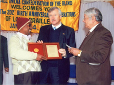 Mr. Babooja Ranjan Choudhary receiving international award for the best Braille essay at a public function organized by All India Confederation of the Blind on the occasion of 202nd Birth Anniversary of Louis Braille